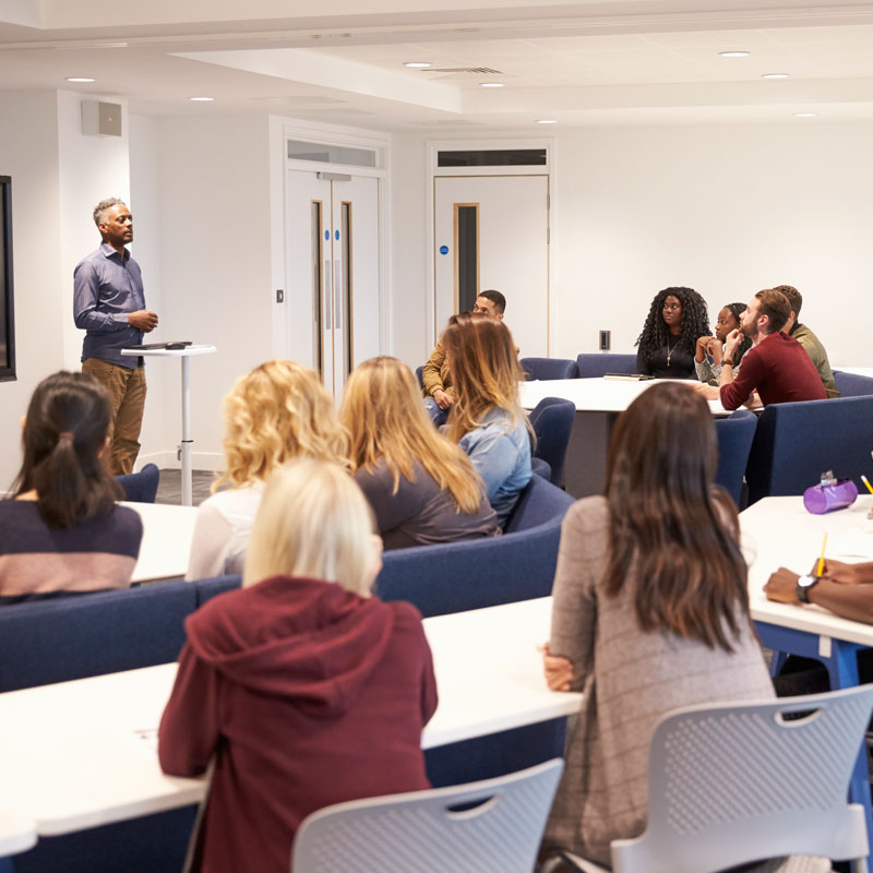 University students study in a classroom with male teacher